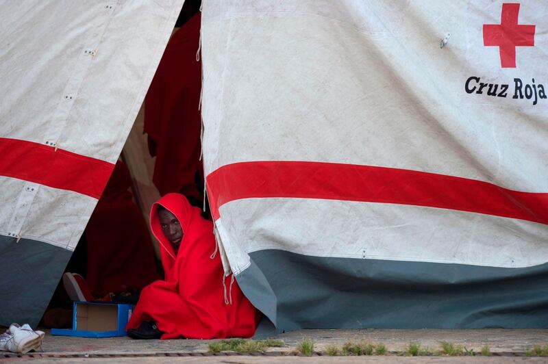 A migrant keeps warm inside a Red Cross tent in Malaga, Spain.  Jorge Guerrero / AFP Photo
