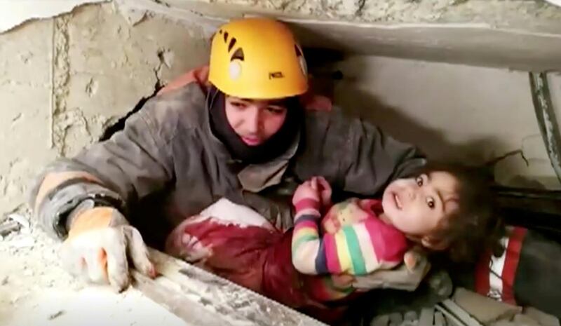 A rescue worker holds a child that was found alive in the rubble of a collapsed building in Elazig, Turkey.  Reuters