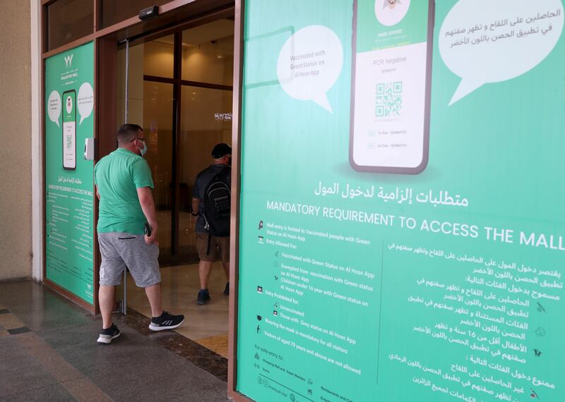 Signs at Khalidiyah Mall inform customers about the current 'green pass' entry rules. People are required to have the 'green status' on the Al Hosn app to enter many public places.