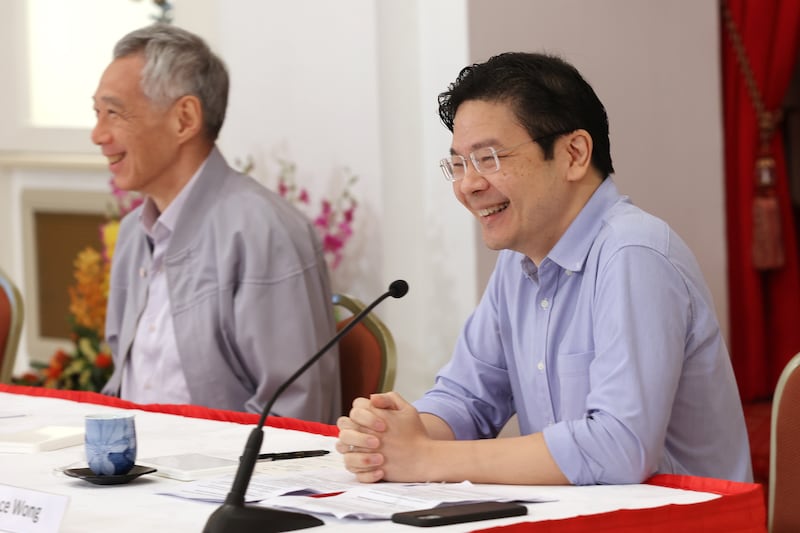 Singapore Finance Minister Lawrence Wong, right, speaks as Prime Minister Lee Hsien Loong looks at the Presidential Palace in Singapore on Saturday. EPA