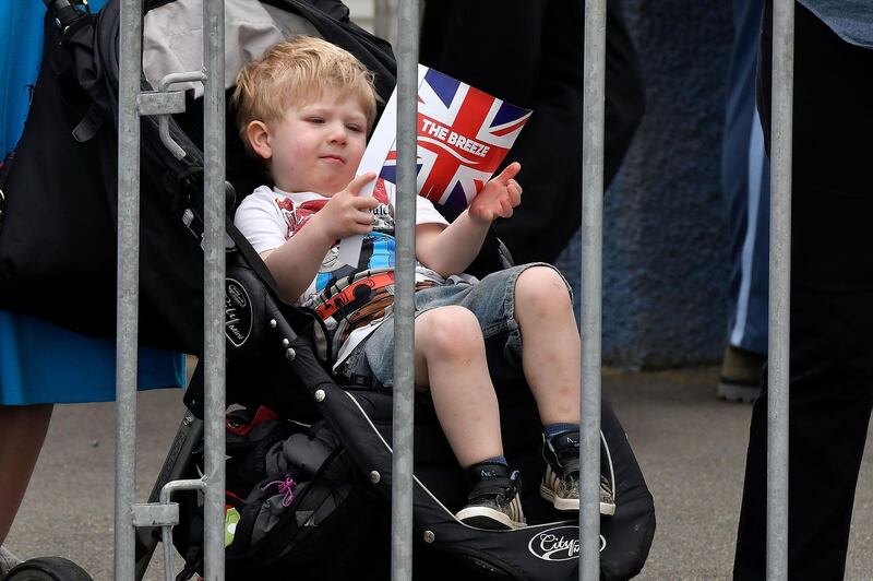 A young royal fan waves a flag ahead of the Duke and Duchess of Sussex's arrival. AFP