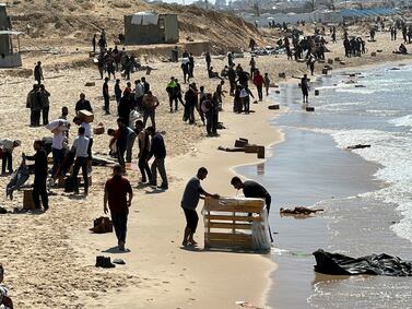Gazans gather on a beach to collect aid dropped into the besieged enclave. Reuters