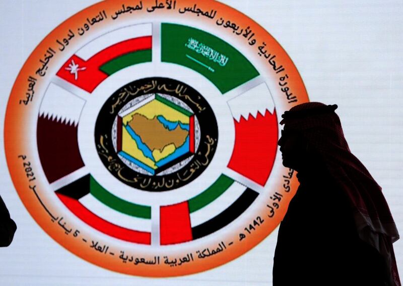 A Saudi television anchor stands in front of the logo of the 41st Gulf Cooperation Council (GCC) at the media centre at Al Ula, Saudi Arabia. AP
