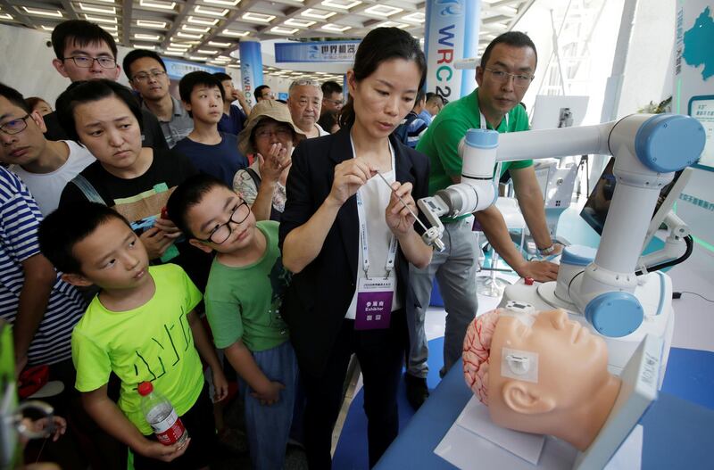 A staff member performs a robot surgery at Tinavi's booth at the World Robot Conference in Beijing, China. Reuters