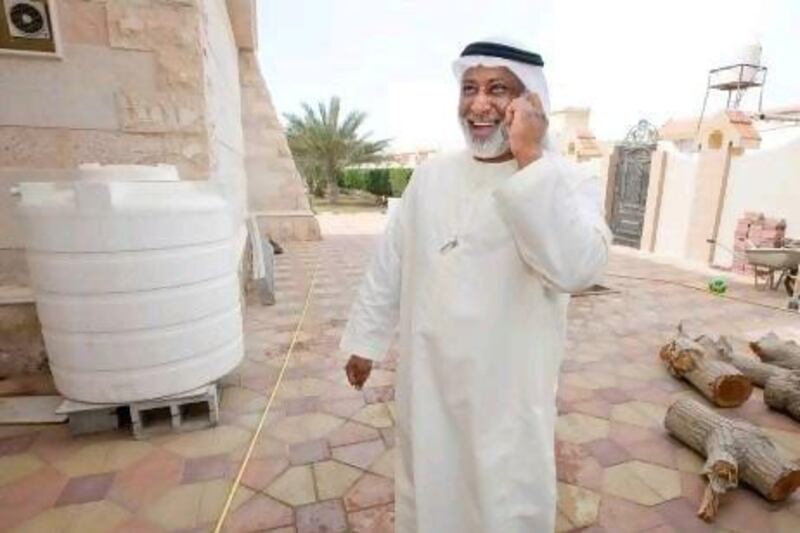 Saif Hassan talk by phone beside his water tank at his villa.