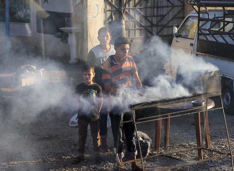 Local residents fry meat on an open fire in the outskirts of the Syrian capital of Damascus. AP