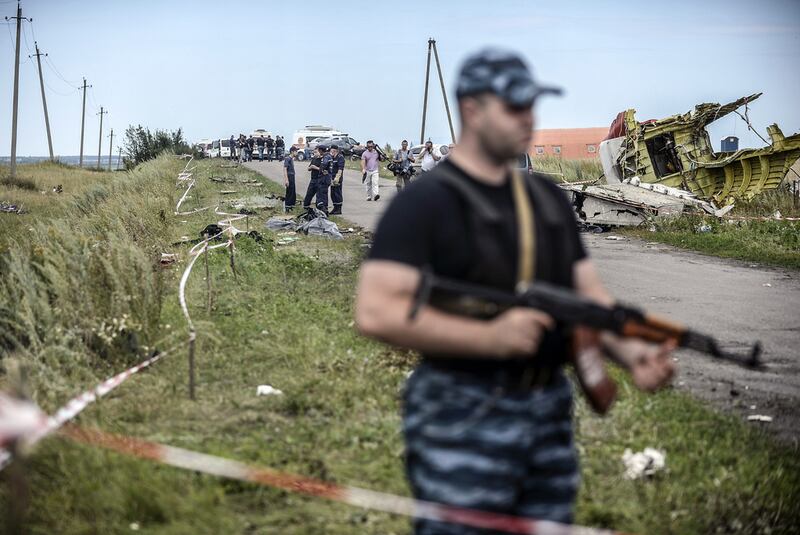 Armed pro-Russian separatists stand guard in front of the crash site of Malaysia Airlines Flight MH17, near the village of Grabove, in the region of Donetsk on July 20, 2014. The missile system used to shoot down a Malaysian airliner was handed to pro-Russian separatists in Ukraine by Moscow, says US secretary of state John Kerry. Bulent Kilic/AFP Photo