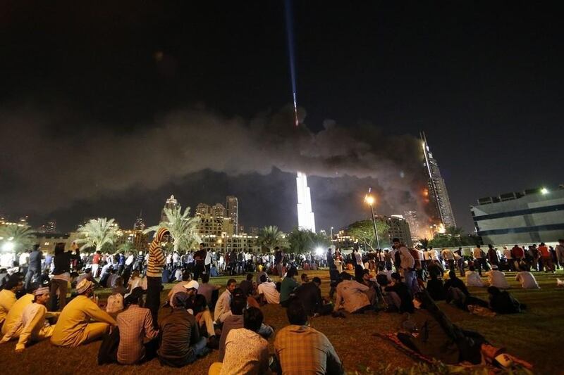 People watch the Address Downtown hotel burning after huge fire ripped through the luxury hotel near the world’s tallest tower, in Dubai. Karim Sahib / AFP Photo