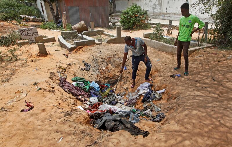 One man tried to find the clothes worn last worn by his missing sister in a pile of garments belonging to the victims of Saturday's attack in Mogadishu, Somalia. AP