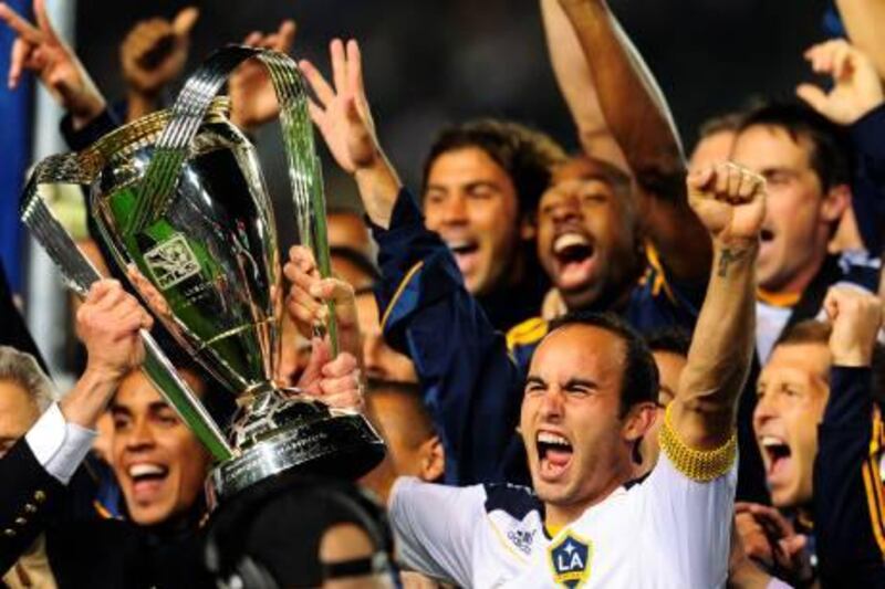 MVP and game-wining goal scorer Landon Donovan (R) lifts the winning trophy following victory over the Houston Dynamo in their MLS Cup final at the Home Depot Center in Carson, California on November 20, 2011.  The LA Galaxy defeated the Houston Dynamo 1-0. AFP PHOTO / Frederic J. BROWN