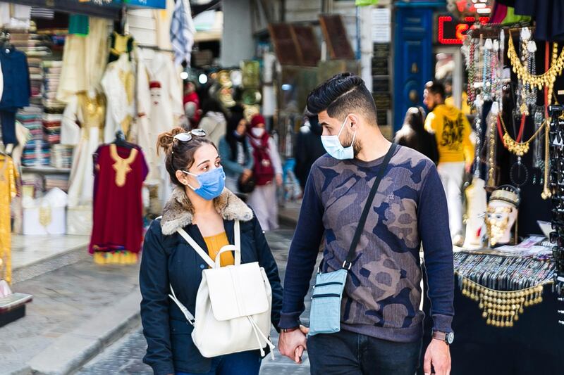 A couple walks in a street market in Tunis. Tunisia is extending its nighttime curfew by three hours and tightening other restrictions ahead of Ramadan following an uptick of COVID-19 infections. The measure will apply from Friday until at least April 30. AP Photo
