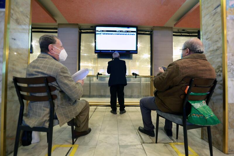 Iraqi investors look at an electronic board showing shares information at the Iraqi Stock Exchange in Baghdad. EPA