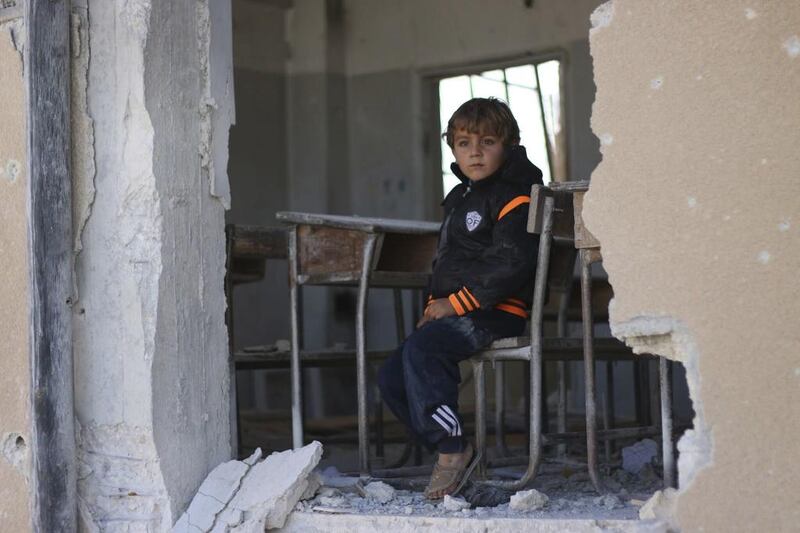 A Syrian boy Ahmed, 6, sits on a damaged classroom in a school in Idlib, north Syria.The UN's child relief agency says at least 652 children were killed in Syria last year, making 2016 the worst year yet for the country's rising generation. Unicef via AP 