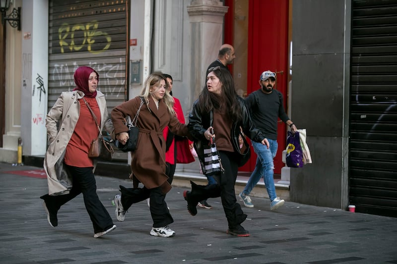 Shoppers run away from the busy shopping street. AP