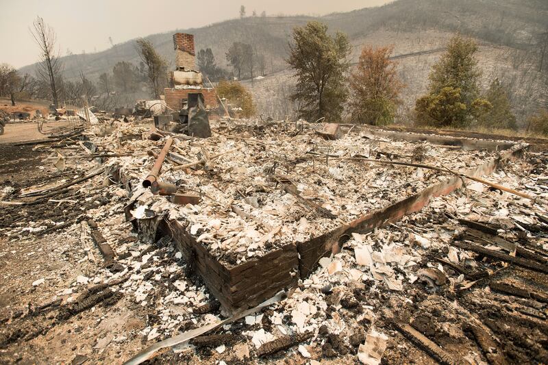 A chimney stands at a burned residence on Yaqui Gulch Road as a wildfire burns near Mariposa, California. The fire has forced thousands of people from homes in and around a half-dozen small communities, officials said. Noah Berger / AP Photo