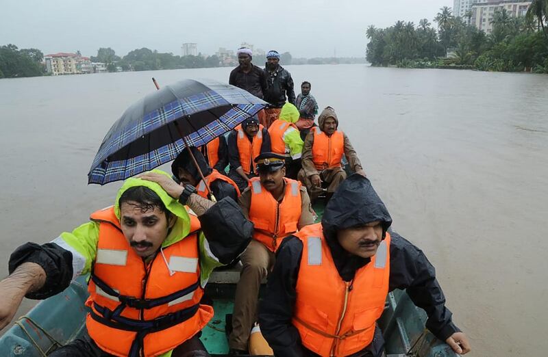 Indian fire and rescue personnel evacuate local residents in an boat flooded following monsoon rains at Aluva, in the Indian state of Kerala, on August 16, 2018. - The death toll from floods in India's tourist hotspot of Kerala increased to 77 on August 16, as torrential rainfall threatened new areas, officials told AFP. (Photo by - / AFP)