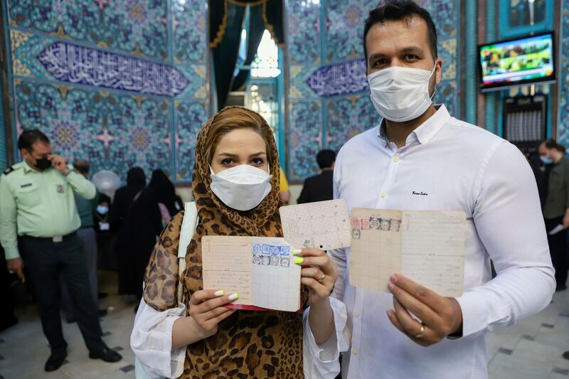 An Iranian couple hold documents after voting during presidential elections at a polling station in Tehran, Iran. Reuters