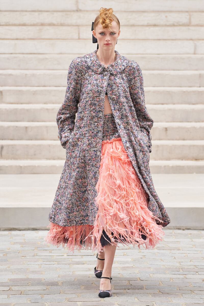 A coat of sequins is worn over a skirt made from feathers at Chanel.