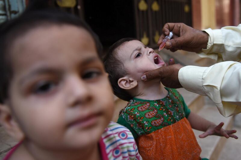 A Pakistani health worker administers polio vaccine drops to a child during a door-to-door polio campaign in Karachi on September 26, 2016.

Pakistan is one of only three countries in the world where polio remains endemic but years of efforts to stamp it out have been badly hit by reluctance from parents, opposition from militants and attacks on immunisation teams. / AFP PHOTO / RIZWAN TABASSUM
