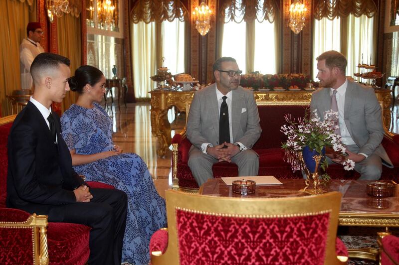 Meghan, Duchess of Sussex sits with Moulay Hassan, Crown Prince of Morocco, as Prince Harry chats with King Mohammed VI of Morocco. Getty Images