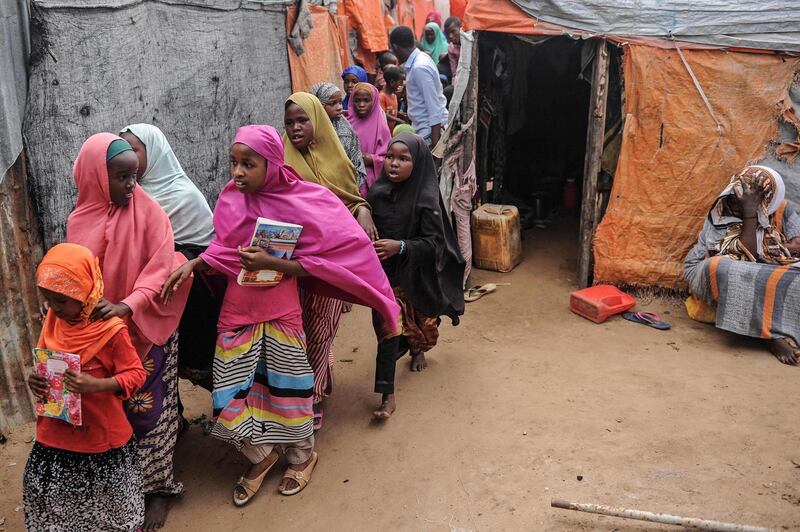 Displaced Somali children and teenagers leave after attending a class to learn alphabets and numbers at a makeshift school at the Badbado IDP camp in Mogadishu, Somalia, on June 25, 2018.  University Students from various universities provide voluntarily free schooling to about 600 girls and boys under 16 at various IDP camps in Mogadishu since May 2017. / AFP / Mohammed ABDIWAHAB
