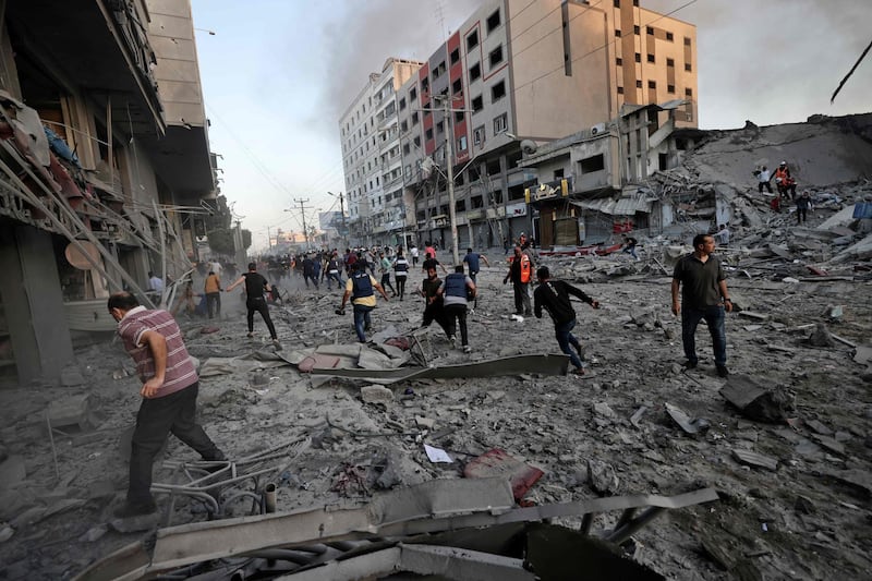 Rescuers and others in the rubble in front of Al Shorouq tower that collapsed after being hit by an Israeli air strike, in Gaza City. AFP