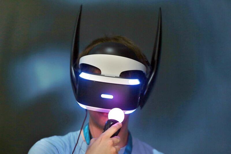 A visitor wears VR goggles while playing the computer game Batman from Sony at the game fair. Oliver Berg / AFP