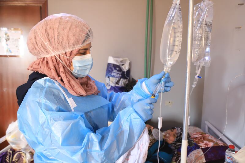 A nurse injects medicine in the serum of one of the patients in the Covid-19 isolation hospital in Idlib. Abd Almajed Alkarh for The National