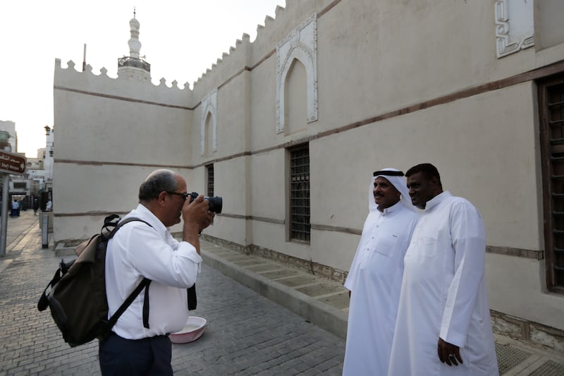 Saudi Arabians pose for a German tourist in front of Al Shaf'i Mosque. AP Photo