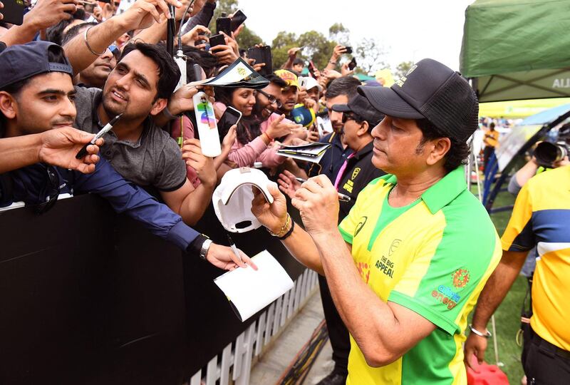 (FILES) In this file photo taken on February 9, 2020 former Indian player Sachin Tendulkar (R) signs autographs during a celebrity cricket match to raise funds for people affected by the Australian bushfires, in Melbourne. Tendulkar announced on March 27, 2021 via his Twitter account that he has tested positive for the COVID-19 coronavirus "following mild symptoms". - -- IMAGE RESTRICTED TO EDITORIAL USE - STRICTLY NO COMMERCIAL USE --
 / AFP / WILLIAM WEST / -- IMAGE RESTRICTED TO EDITORIAL USE - STRICTLY NO COMMERCIAL USE --
