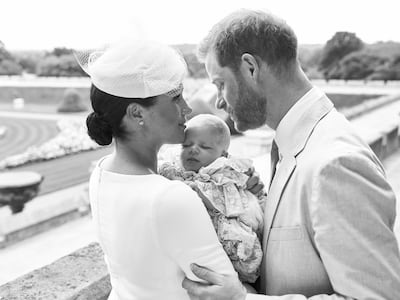 This is an official christening photo released by the Duke and Duchess of Sussex on Saturday, July 6, 2019, showing Britain's Prince Harry, right and Meghan, the Duchess of Sussex with their son  Archie Harrison Mountbatten-Windsor at Windsor Castle with with the Rose Garden in the background, in Windsor, England. (Chris Allerton/Â©SussexRoyal via AP)