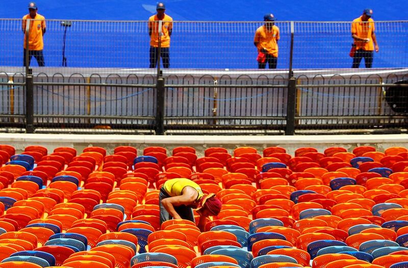 An employee fixes seats inside the Cairo International Stadium ahead of the Africa Cup of Nations opening soccer match between Egypt and Zimbabwe in Cairo, Egypt.  Reuters