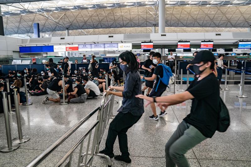 Protesters remove a barricade at the departure hall of the Hong Kong International Airport during a demonstration in Hong Kong, China. Getty Images