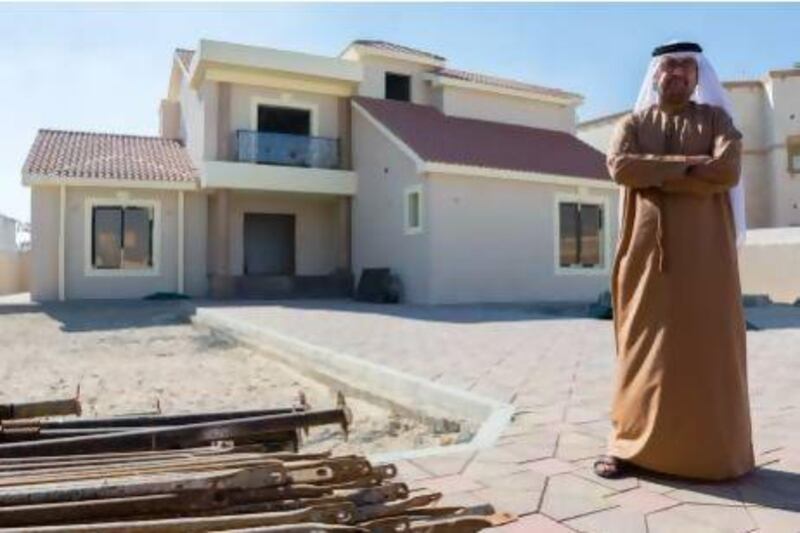 Khalid Al Ali outside the house that he has built over the past 8 years. Duncan Chard / The National