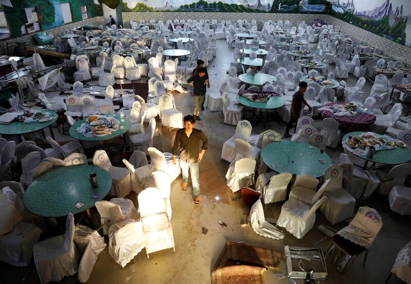 Workers inspect a damaged wedding hall after a blast in Kabul, Afghanistan. Reuters