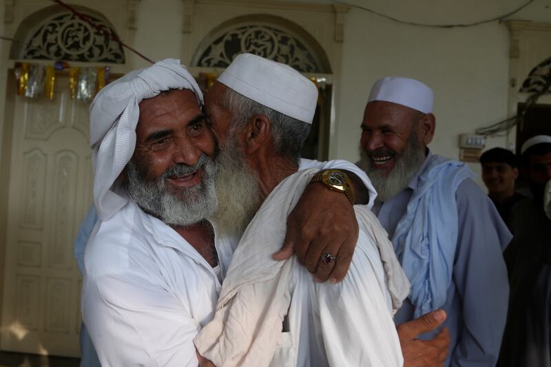Afghan refugees share Eid Al Adha greetings at a mosque in the Kazana refugee camp on the outskirts of Peshawar, Pakistan. AP 