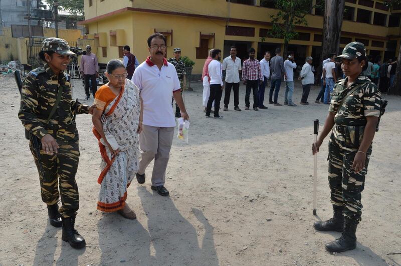 An Indian woman  in Siliguri, West Bengal is helped at polling station. Reuters