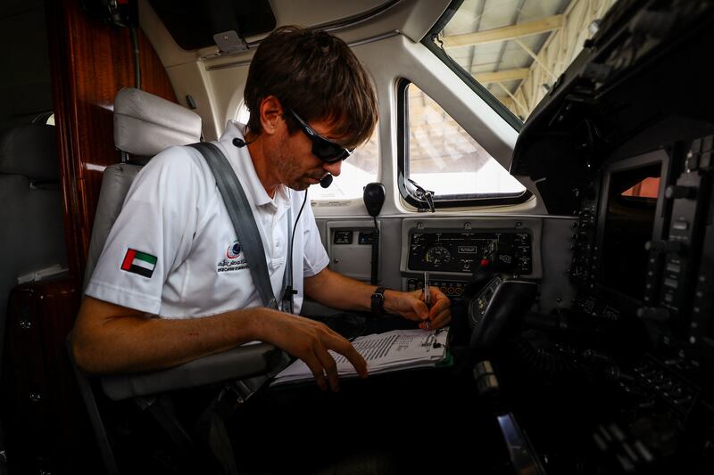 Pilot Michael Anstis writes a weather report before the cloud-seeding flight from Al Ain.