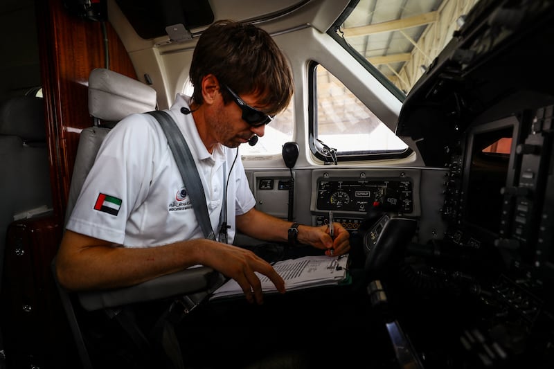 Pilot Michael Anstis writes a weather report before the cloud-seeding flight from Al Ain.