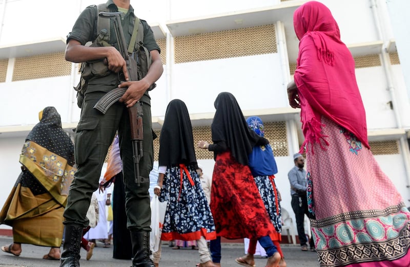 Sri Lankan Army personnel stand guard as Muslim devotees arrive to offer prayers on the first day of Eid al-Fitr at the Grand Mosque in Colombo on July 5, 2019. - Muslims around the world are celebrating the Eid al-Fitr festival, which marks the end of the fasting month of Ramadan. (Photo by LAKRUWAN WANNIARACHCHI / AFP)