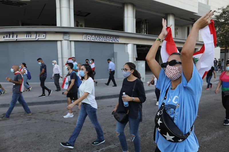 People wave Lebanese flags and chant to mark the first anniversary of anti-government protests in Beirut. Getty Images