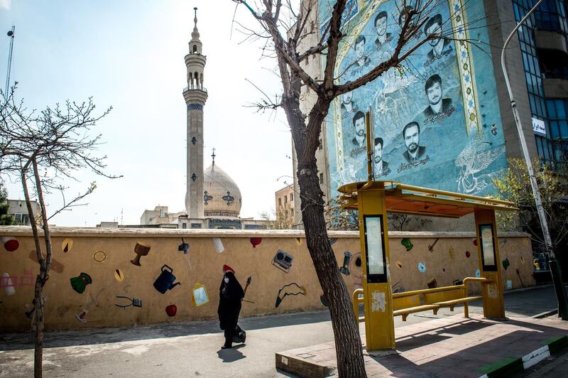 A pedestrian wears a protective face mask while walking in central Tehran, March 15. Bloomberg