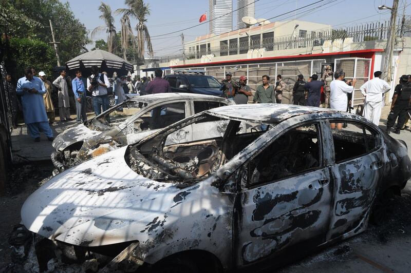 Pakistani security personnel stand next to burnt vehicles in front of the Chinese consulate in after an attack in Karachi. At least two policemen were killed. AFP