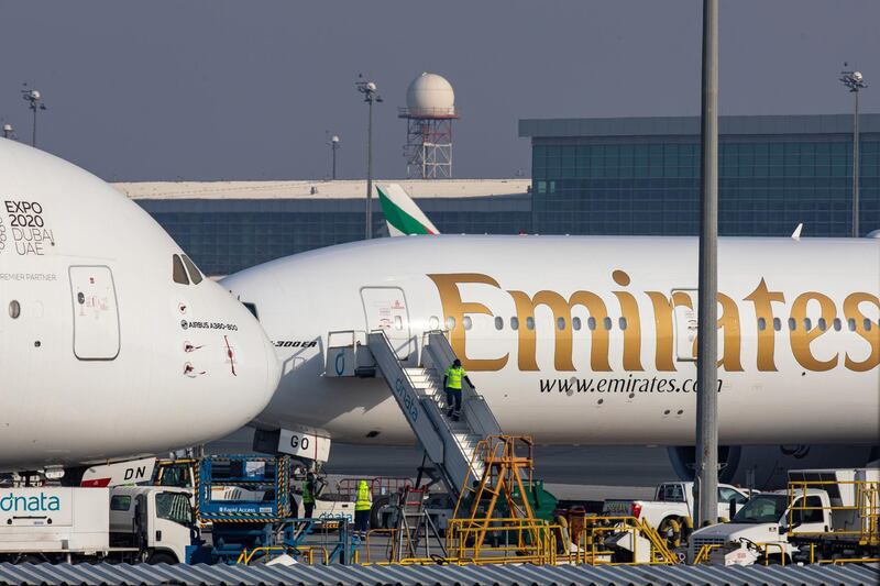A member of the ground crew exits a Boeing Co. 777-300 aircraft, operated by Emirates, while standing next to a Airbus SE A380-800 aircraft in a parking zone at Dubai International Airport in Dubai, United Arab Emirates, on Monday, May 18, 2020. Emirates Group is considering plans to cut about 30,000 jobs as the operator of the world’s largest long-haul carrier seeks to reduce costs after the coronavirus pandemic grounded air travel. Photographer: Christopher Pike/Bloomberg