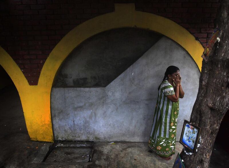 A Tamil woman prays at a Hindu temple near her home in Colombo before the start of the day on January 29, 2014. Dinuka Liyanawatte / Reuters photo