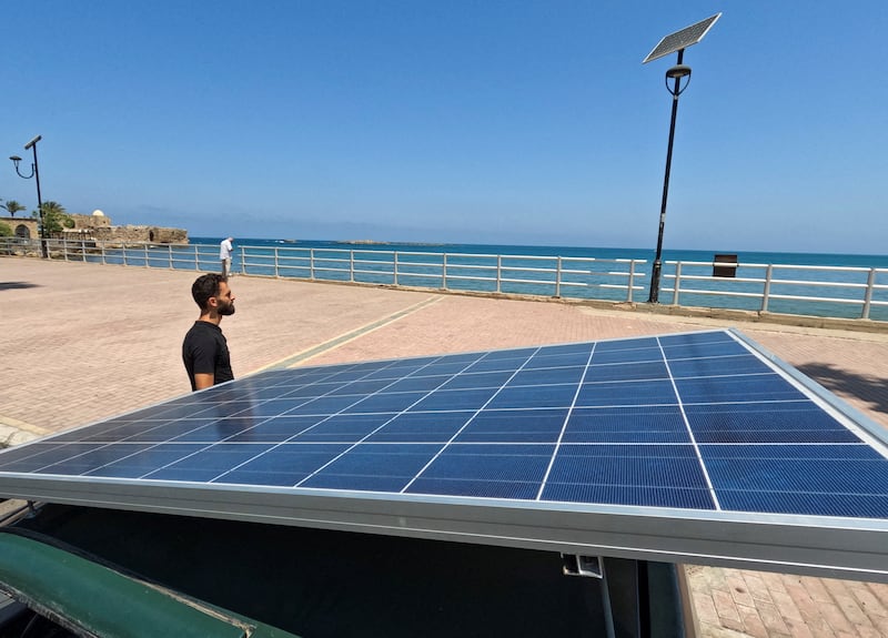 Lebanese repairman Ahmad al-Safadi stands near his custom-made electric vehicle powered by a solar panel at the corniche in port-city of Sidon, Lebanon June 23, 2022.  Picture taken June 23, 2022.  REUTERS / Issam Abdallah