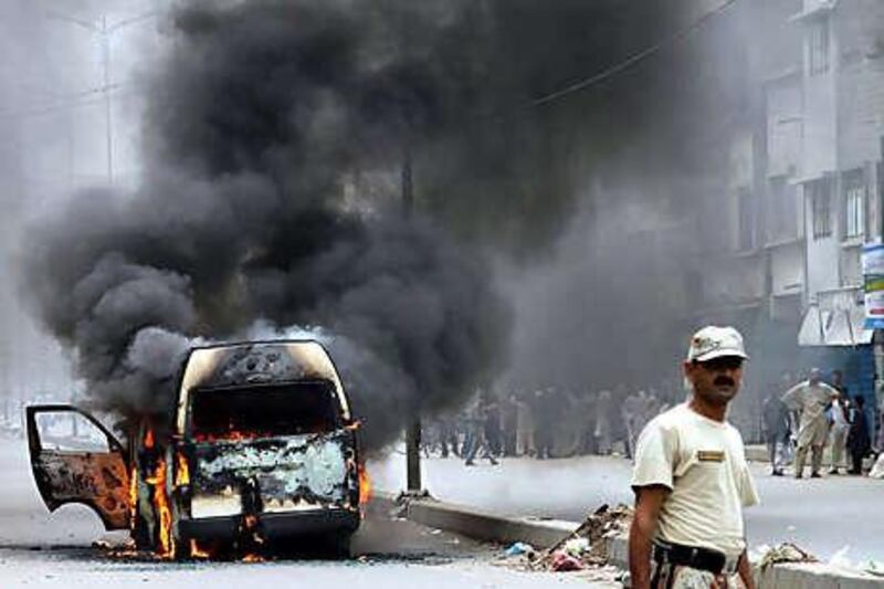 Smoke rises from a bus that had been set on fire after unrest broke out as a result of the killing of Raza Haider, a provincial legislator from Sindh Assembly, in the southern port city of Karachi.