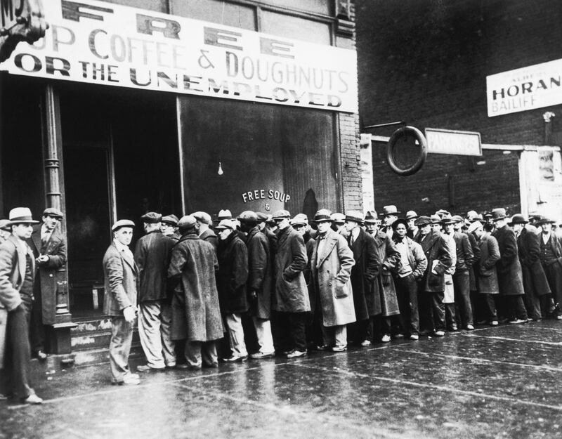 Unemployed men line up outside a Great Depression-era soup kitchen opened in Chicago by Al Capone. The storefront sign reads "Free Soup, Coffee and Doughnuts for the Unemployed." (Photo by Â© CORBIS/Corbis via Getty Images)