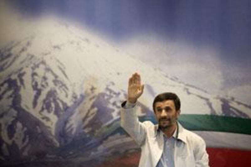 The Iranian president Mahmoud Ahmadinejad waves to journalists as he attends his first news conference after re-election.
