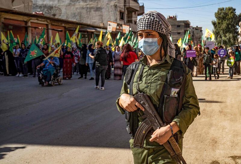 A Syrian Kurdish fighter stands guard during a rally in the northeastern city of Qamishly. AFP